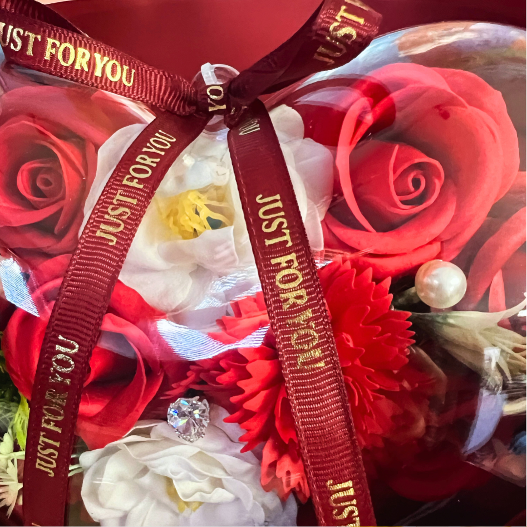 Close-up of red soap flowers in a heart-shaped bouquet with a "Just For You" ribbon.