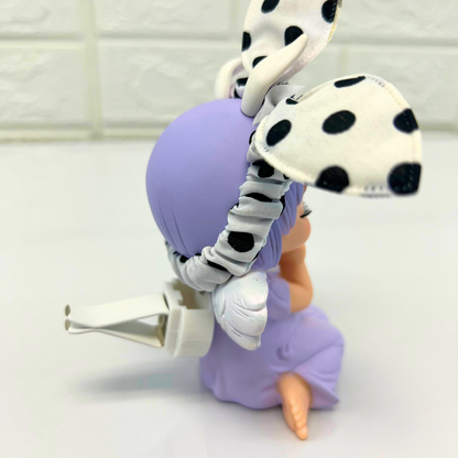 Side view of a purple-haired angel figurine with polka dot bunny ears, showing the attachment clip on the back.