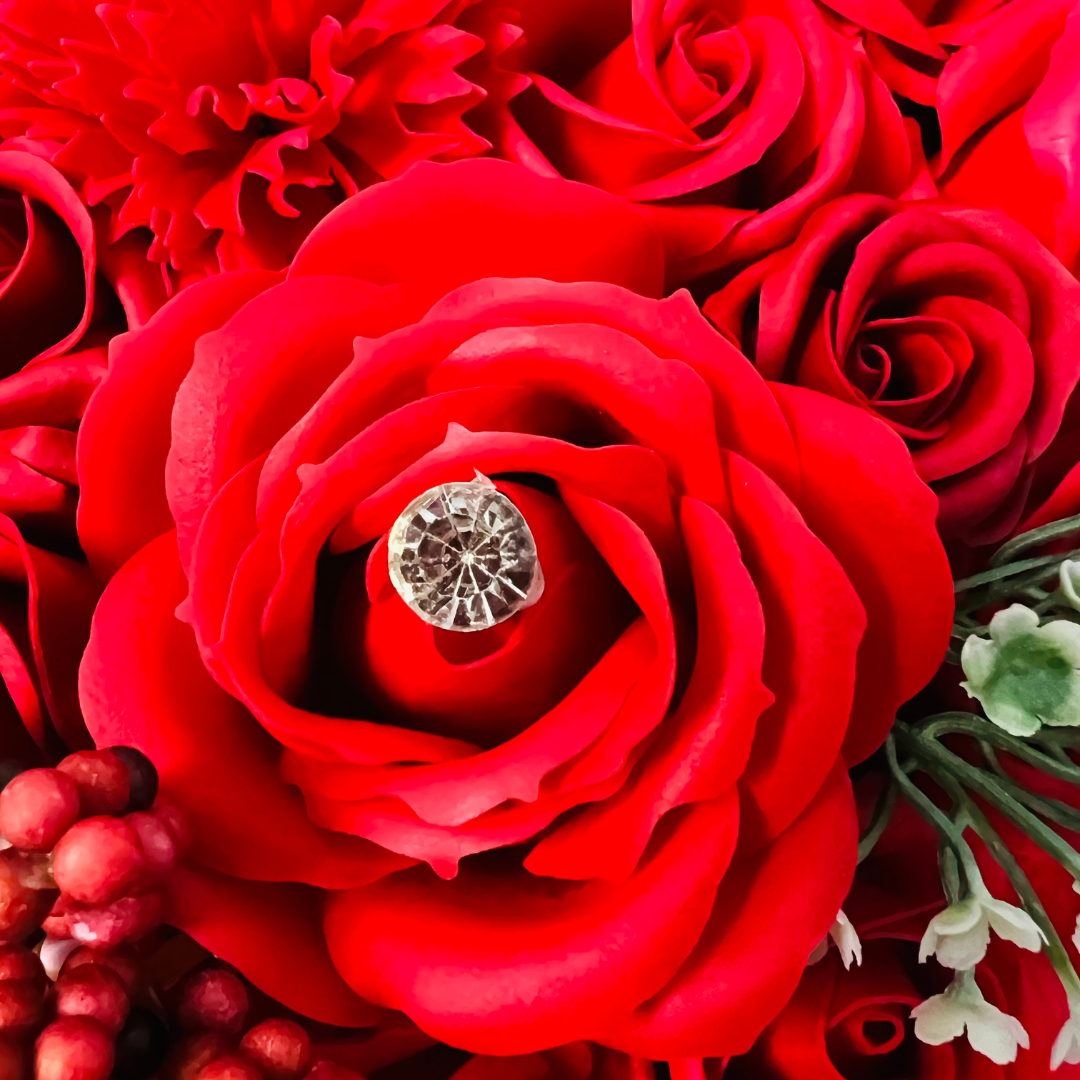 Close-up of vibrant red soap roses with a decorative jewel accent.