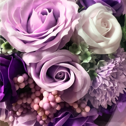 Close-up of lavender soap roses with berry accents in a luxurious arrangement.