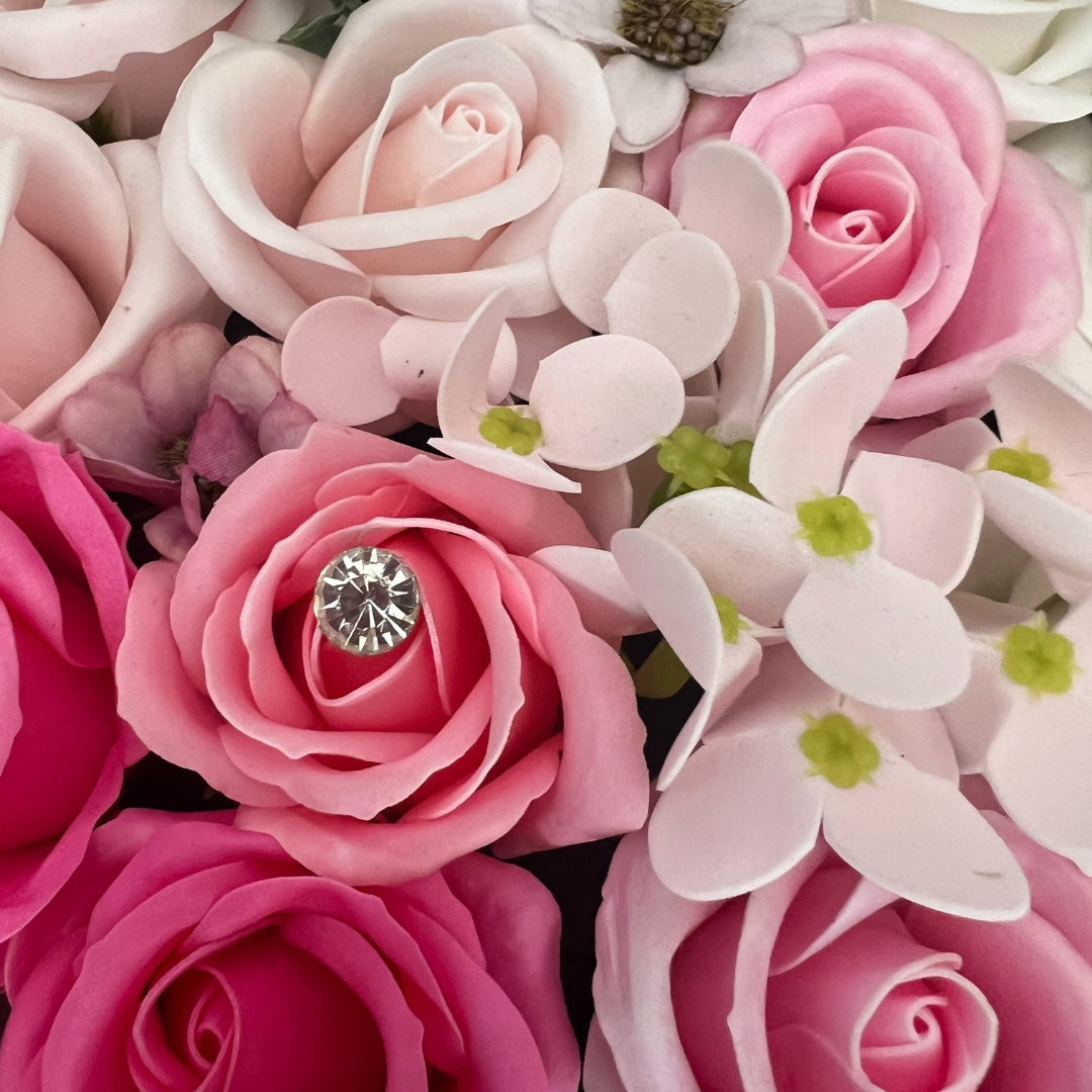 Close-up of pink soap roses with a sparkling jewel accent.